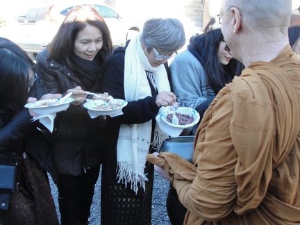 Lay supporters offer rice into Luang Por's bowl