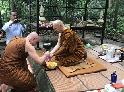 Ajahn Jayasaro paying respects to Luang Por Pasanno on his birthday outside of his cave retreat.