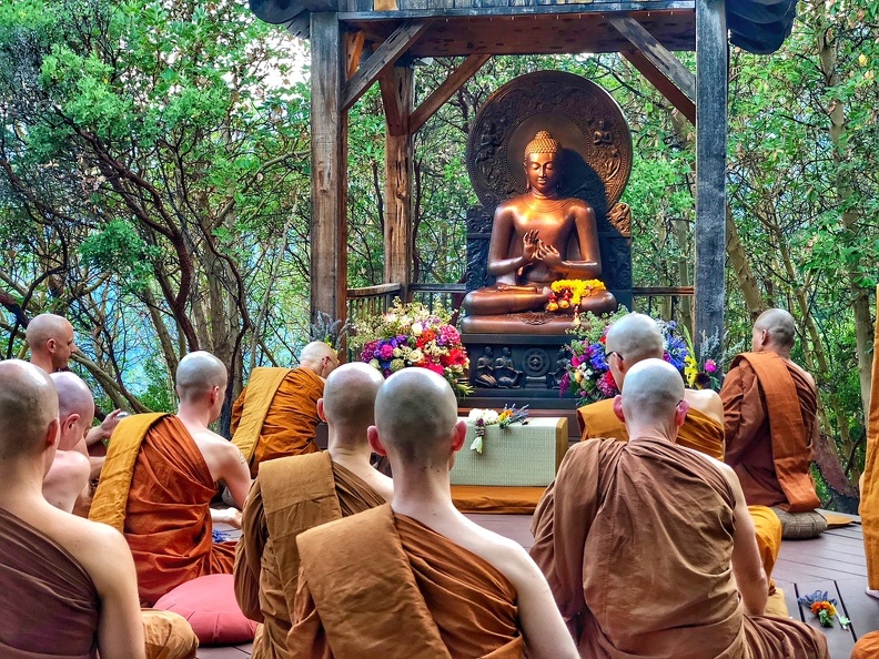 The community gathers at the outdoor meditation platform to celebrate Asalha Puja, commemorating the Buddha's first discourse with an evening of chanting, teaching, and meditation.