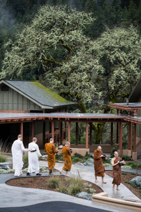 Monks walking to the meal during a drizzle.