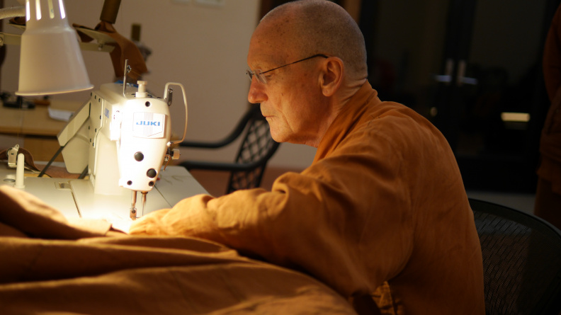 Luang Por Pasanno sewing on the boarder of the Kathina robe
