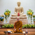 Luang Por Pasanno leads the Songkran celebration with a smile, a bountiful floral backdrop and a livestream audience via YouTube. 