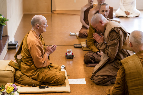 Newly-ordained monk Tan Dhammavaro bows to Luang Por Pasanno, his Preceptor.