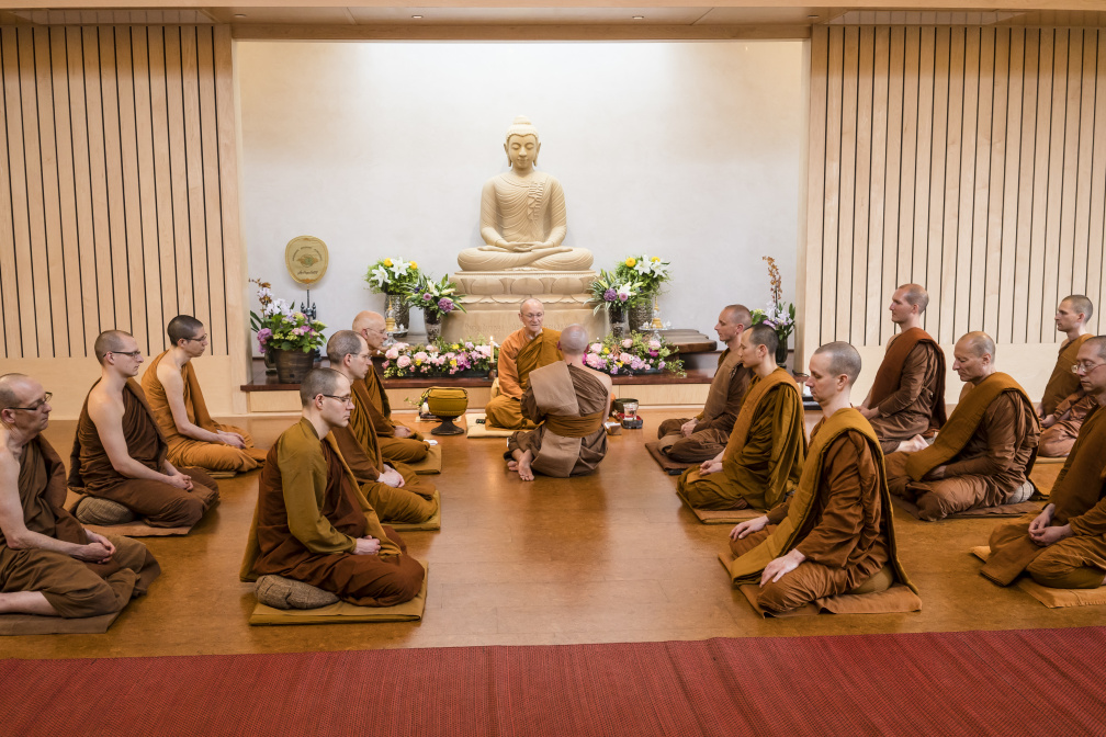 Dressed in his triple robe set, Dhammavaro, center, receives his monk ordination from Luang Por Pasanno in the presence of the Abhayagiri monastic community on May 17, 2020.