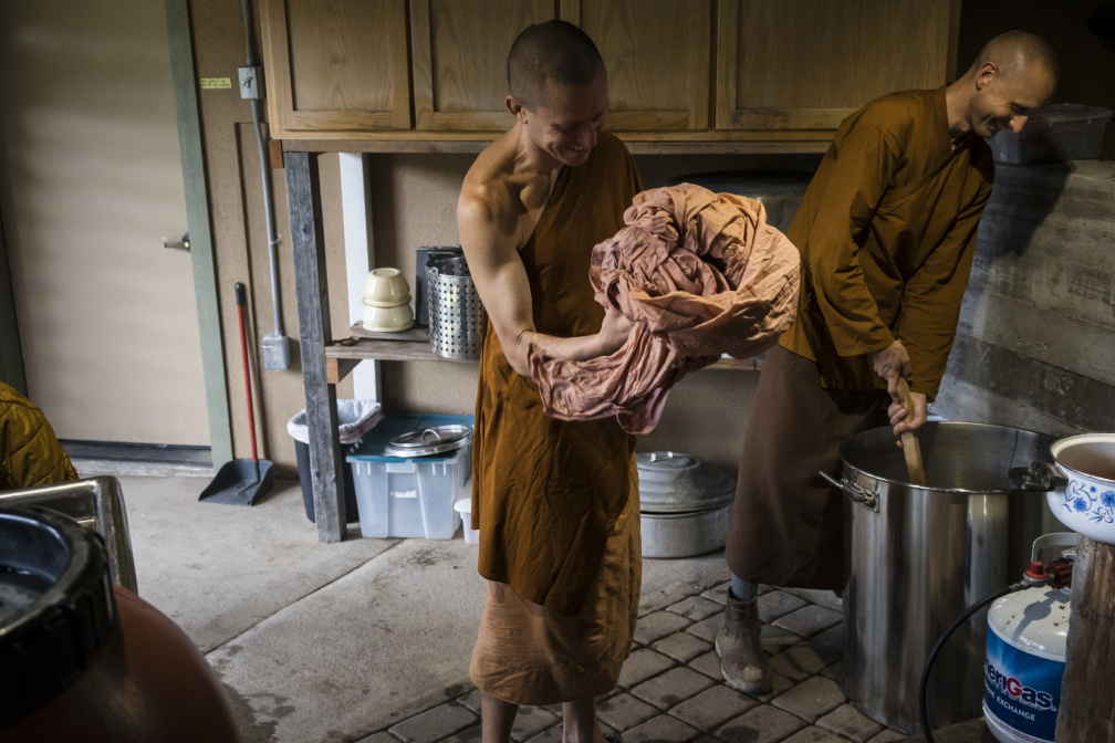 Dhammavavro applies mordant to a robe alongside Ajahn Ñaniko, the abbot of Abhayagiri, who dyed a robe at the same time. It's common for a novice to have dedicated help through this process from a more senior monk.